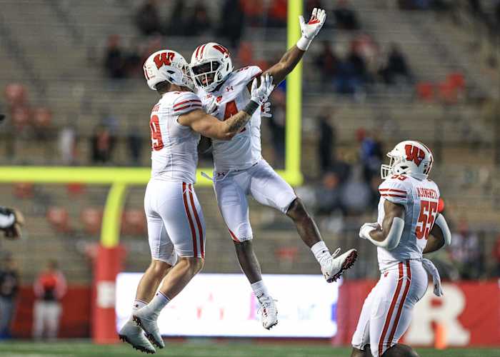 Nov 6, 2021; Piscataway, New Jersey, USA; Wisconsin Badgers linebacker Jordan Turner (54) celebrates his interception with linebacker Nick Herbig (19) and linebacker Maema Njongmeta (55) during the second half against the Rutgers Scarlet Knights at SHI Stadium. Mandatory Credit: Vincent Carchietta-USA TODAY Sports